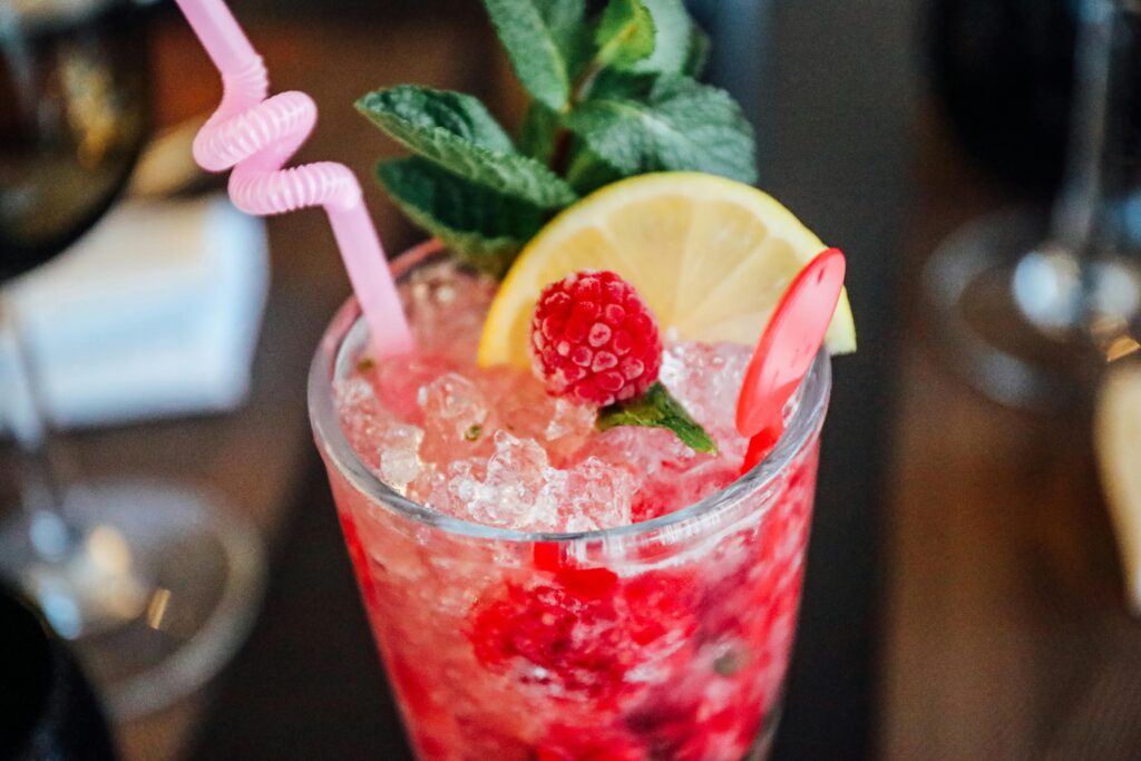Chilled raspberry and mint cocktail garnished with lemon slice in a glass, perfect for a refreshing treat.