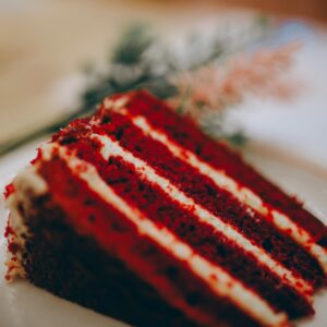 Close-up photo of a red velvet cake slice on a plate, highlighting its rich color and texture.