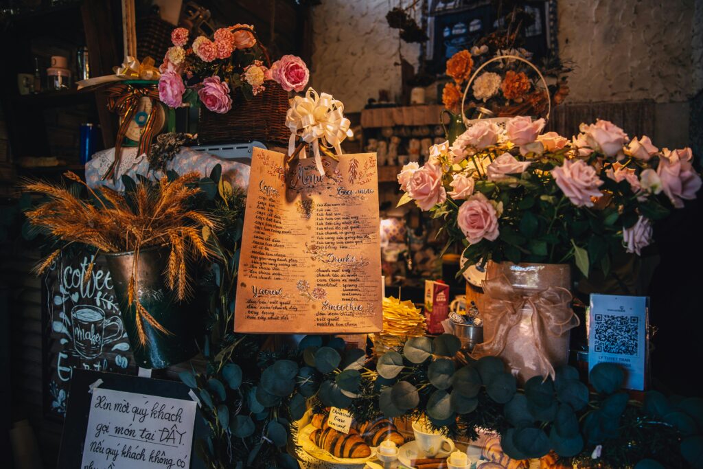 Charming café counter adorned with floral decor, handwritten menu, and rustic aesthetics.